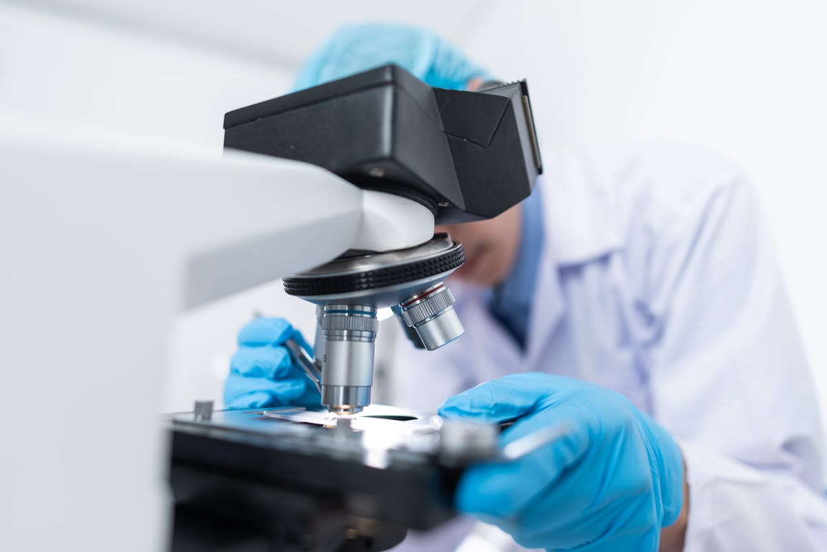 Lab technician analyzing samples under microscope
